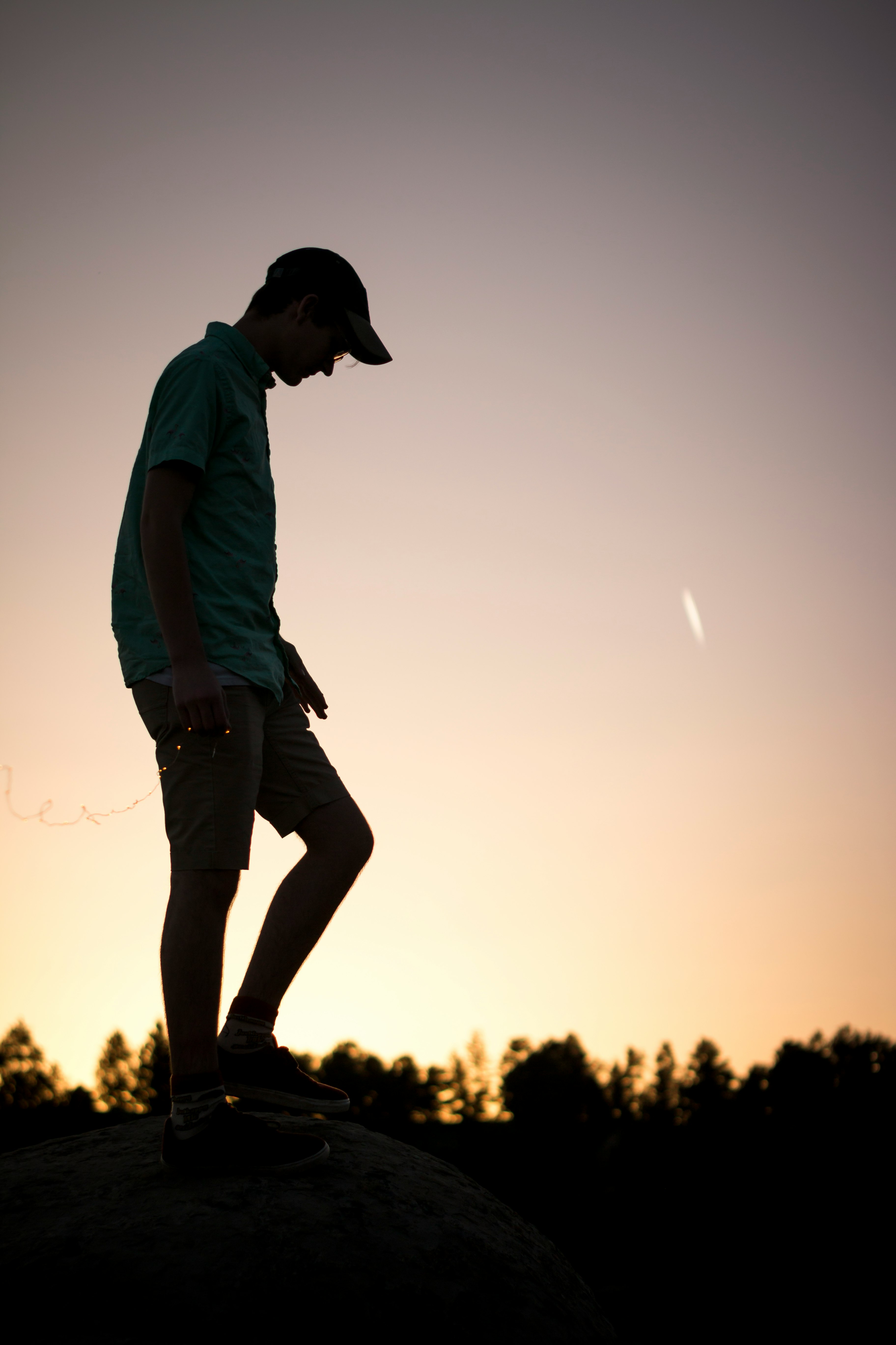 man standing on rock under clear sky